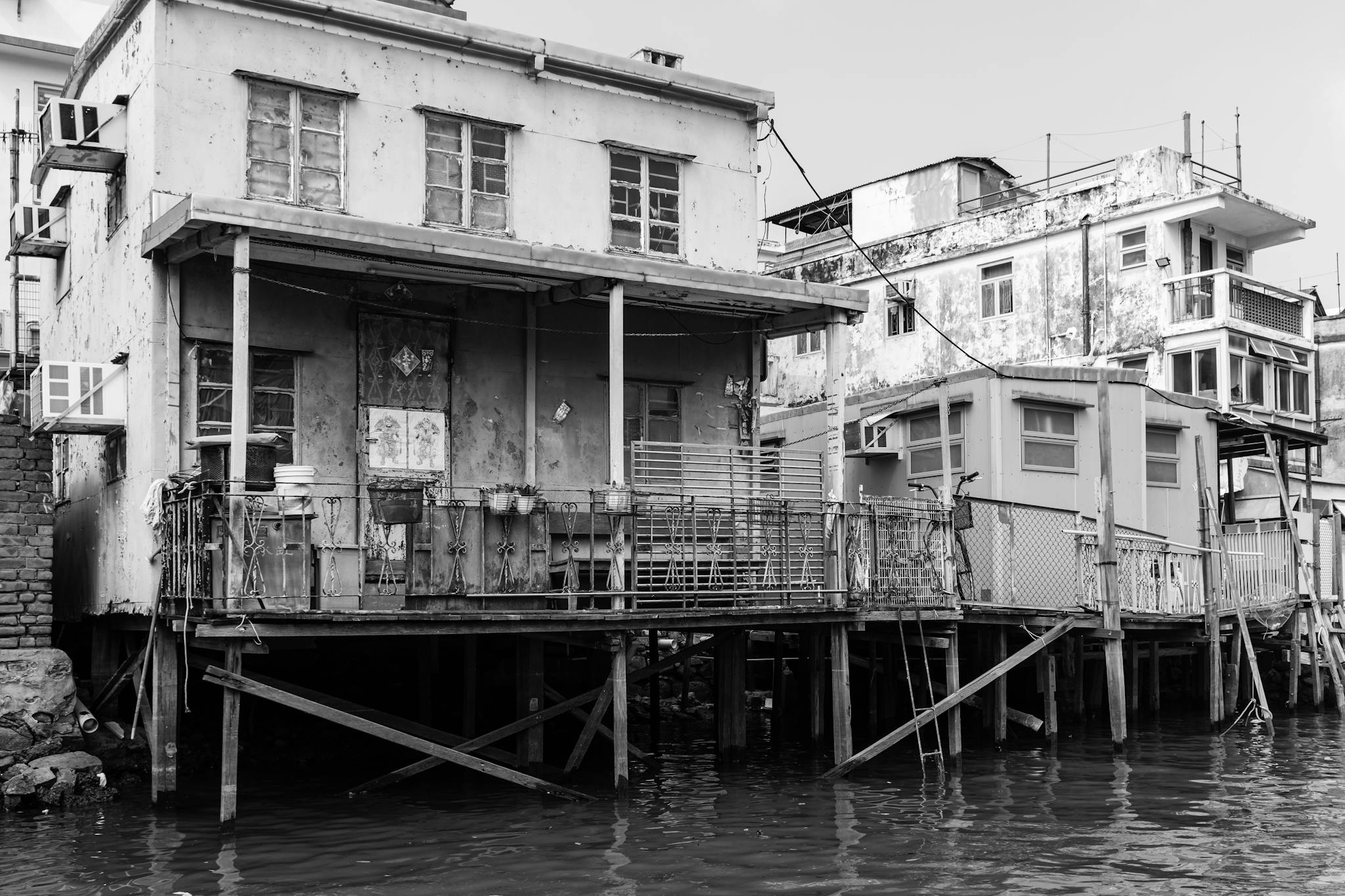 Black and white image of traditional stilt houses in Tai O, capturing rustic architecture.