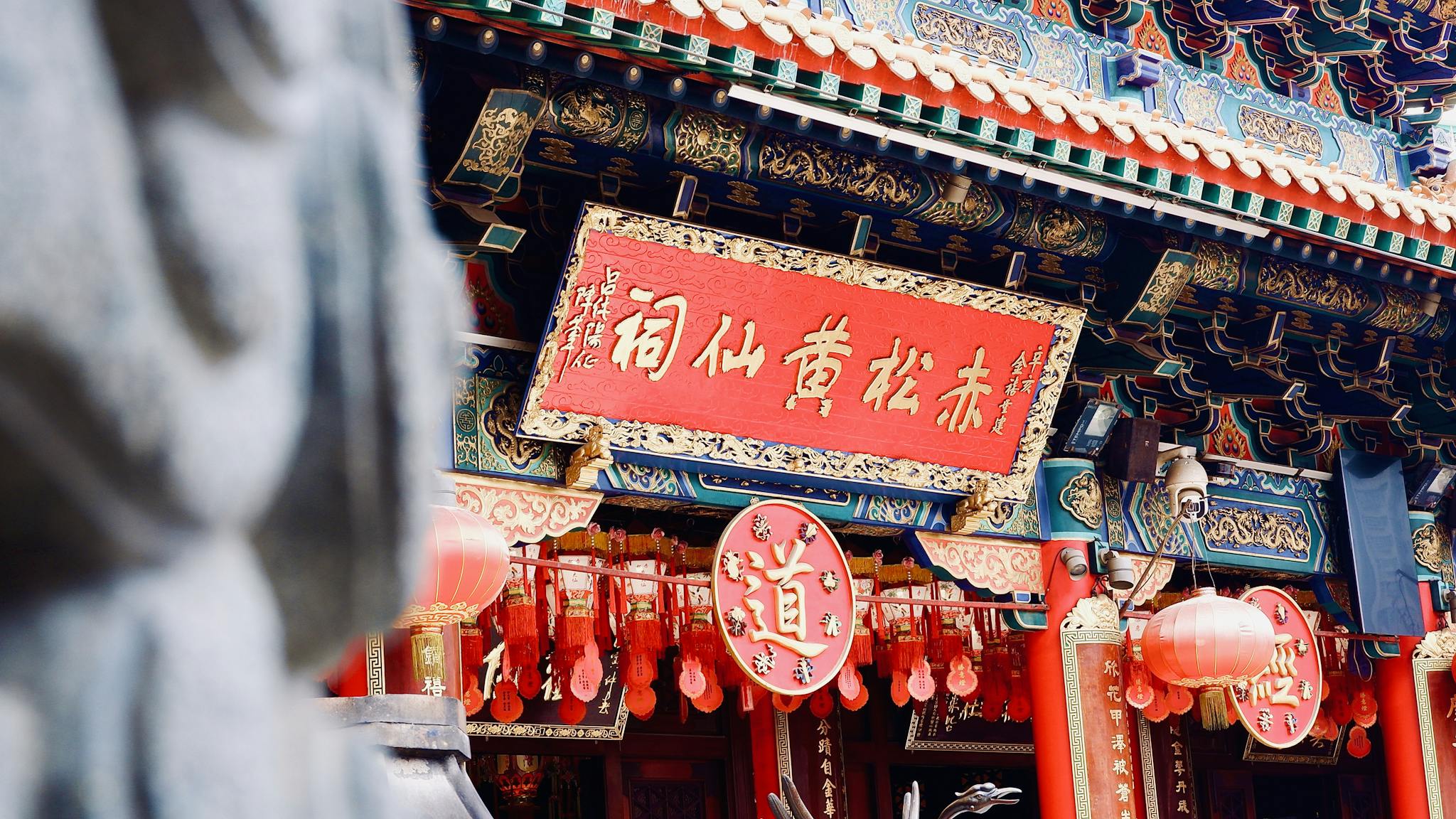 Explore the vibrant architecture and red lanterns at Hong Kong's Wong Tai Sin Temple.